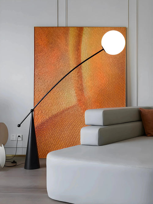 Amalfi sculptural arc floor lamp beside sofa with orange wall background