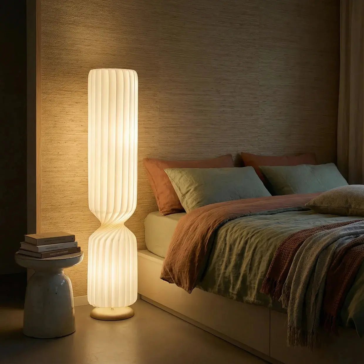 Solenne ribbed sculptural floor lamp glowing warm beside bed dark green bedroom