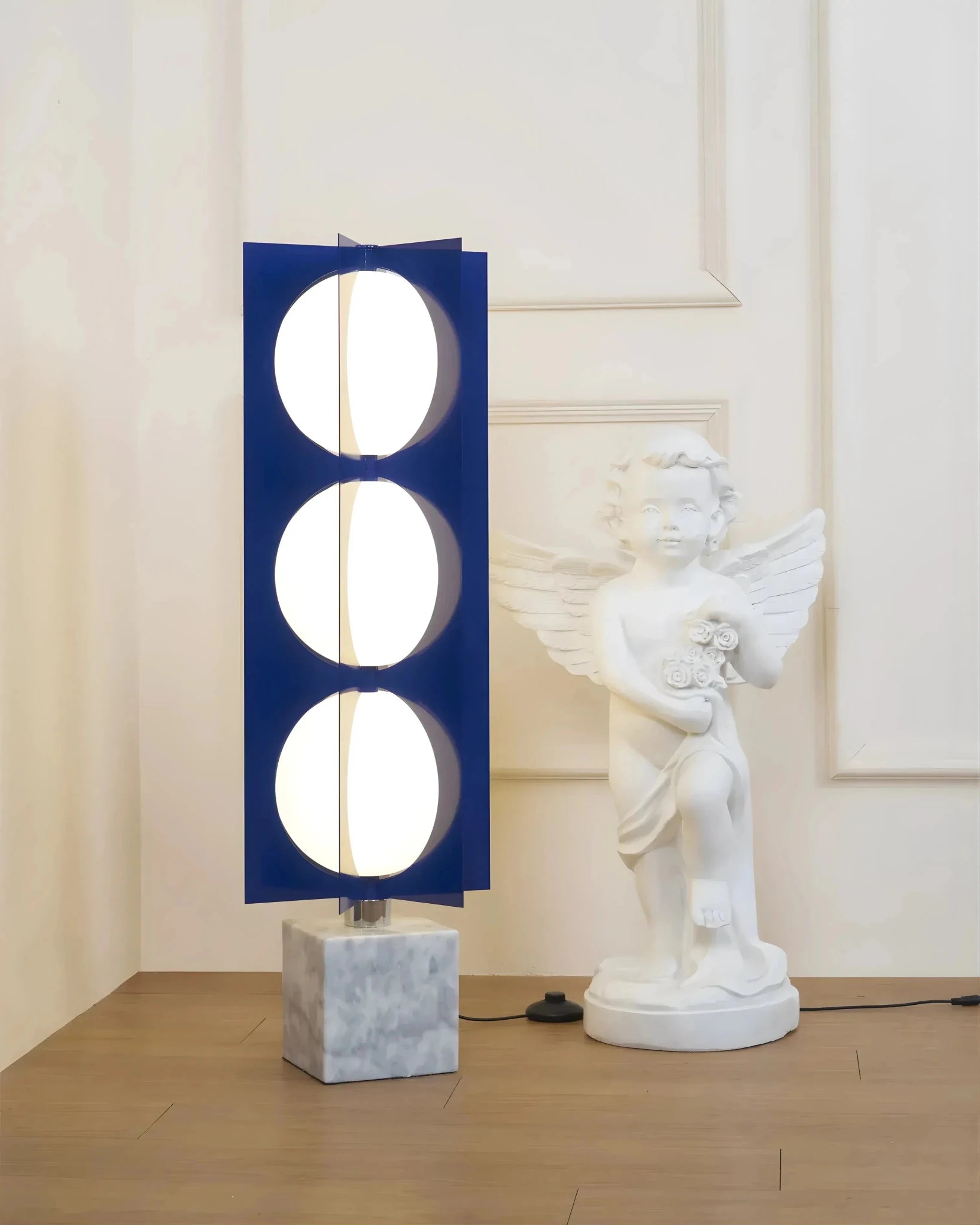 Verona cascade tower table lamp navy blue beside white sculpture in bright room